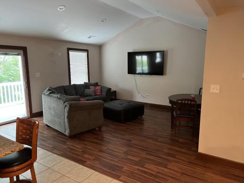 a living room with a couch and a tv on the wall at Luxury Beach Side Home home in North Camellia Acres