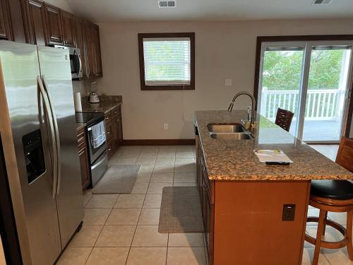 a kitchen with a stainless steel refrigerator and a sink at Luxury Beach Side Home home in North Camellia Acres