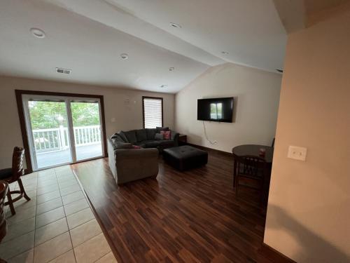 a living room with a couch and a tv at Luxury Beach Side Home home in North Camellia Acres