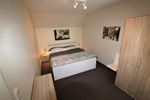 a small bedroom with a bed and a closet at Rosen-Haus in Fehmarn