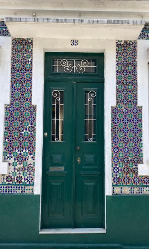 a green door on the side of a building at Casa da Genoveva - Typical House in Aveiro