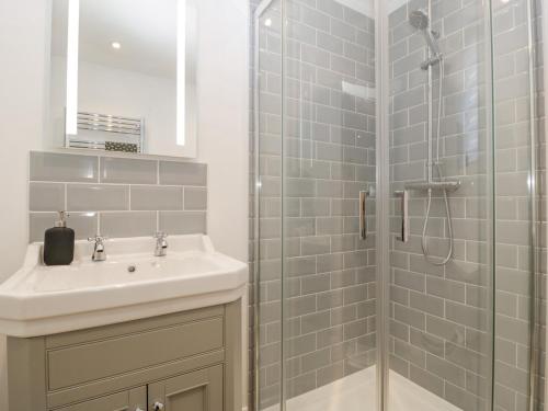 a bathroom with a sink and a glass shower at Barrow Lodge in Blandford Forum