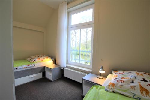 1 dormitorio con 2 camas y ventana en Obere Teichwohnung, en Fehmarn