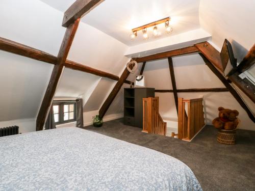 1 dormitorio con 1 cama grande en el ático en Thimble Cottage en Blandford Forum