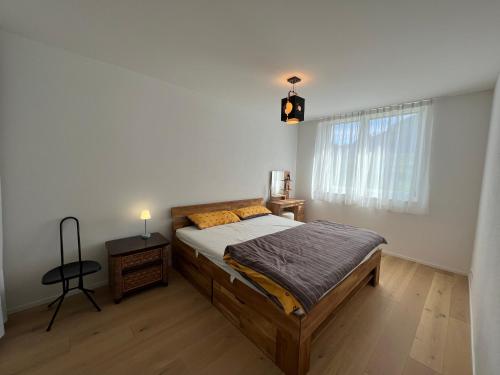 1 dormitorio con cama, mesa y ventana en Wohnung auf dem Bürgenstock, en Kehrsiten