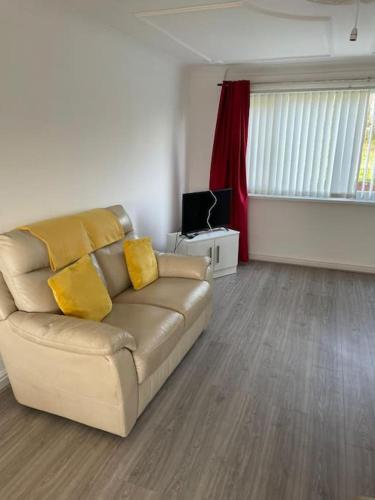 a living room with a couch and a television at 3 Bed Sleep 6, Bootle/Aintree in Bootle