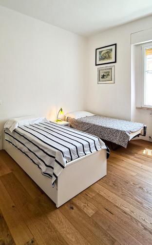 a bedroom with two beds and a wooden floor at Dorico Apartment in Ancona