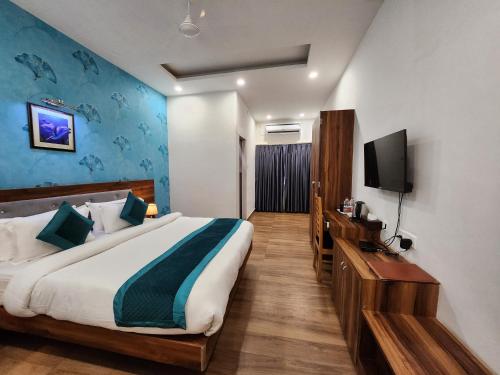 a bedroom with a large bed and a television at Hotel Golden Palm in Patna