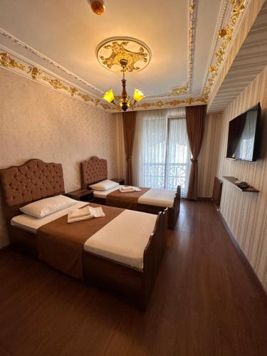 Cette chambre comprend deux lits et un lustre. dans l'établissement fafsuitehome, à Istanbul