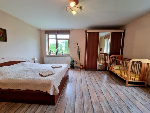 Un dormitorio con una cama y una ventana y una cuna. en Cozy Apartment Magnolia, en Ventspils