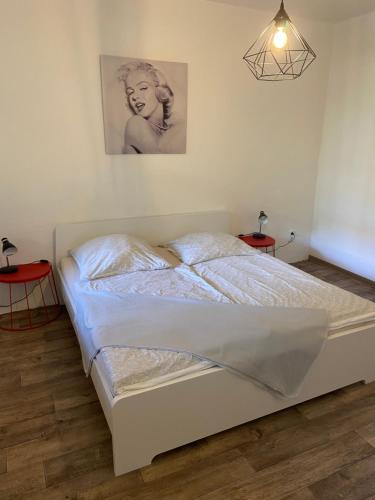 a white bed in a bedroom with two tables at Ferienwohnung am Friedenspark 2 in Thale