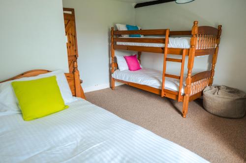 a bedroom with a bunk bed and a bunk bed with a green pillow at Poyers Farmhouse in Wrafton