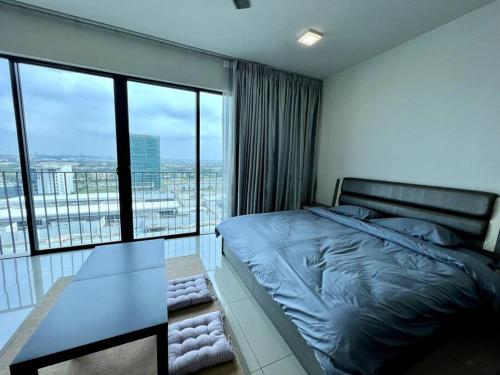 a bedroom with a bed and a view of a city at Cozy Couple Suite at Trefoil Setia Alam in Shah Alam