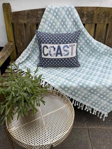 a cushion sitting on a chair next to a table at Poyers Farmhouse in Wrafton