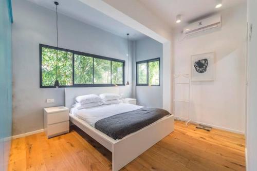 a bedroom with a large bed and two windows at TLV beach 4 rooms big balcony / 125 m2 appart in Tel Aviv