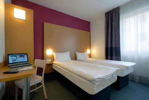 Habitación de hotel con cama y escritorio con ordenador portátil en B&B Hotel Prague City en Praga