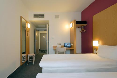 um quarto de hotel com uma cama e uma secretária em B&B Hotel Prague City em Praga