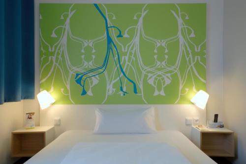 a bedroom with a bed with a green wall at B&B Hotel Paderborn in Paderborn