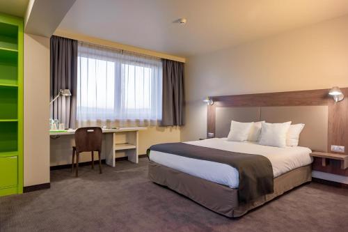 ノヴィ・タルクにあるB&B Hotel Nowy Targ Centrumのベッドとデスクが備わるホテルルームです。