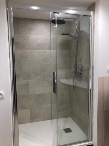 a shower with a glass door in a bathroom at Demain Rando ! in Bielle