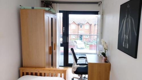 a room with a desk and a chair and a window at London Anayah apartments in London