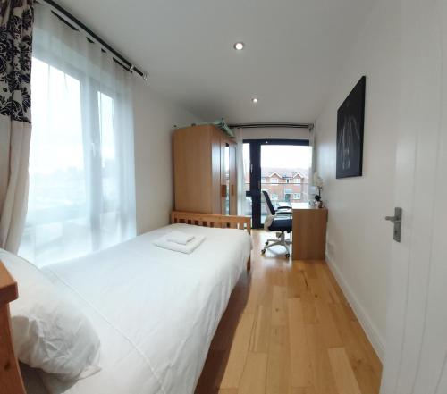 a bedroom with a white bed and a large window at London Anayah apartments in London