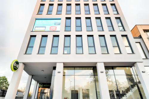 a tall white building with large windows at B&B Hotel Nürnberg-West in Nürnberg