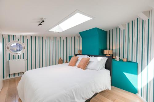 1 dormitorio con 1 cama grande con rayas azules y blancas en Péniche de prestige à Namur avec vue sur la Citadelle - A l'Abordage - By Voyages Copine, en Namur