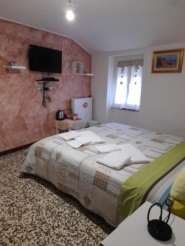 um quarto com uma cama grande e uma televisão na parede em A Ridosso em Riccò del Golfo di Spezia