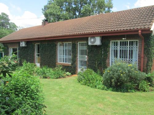 a small brick house with a grass yard at Howick Greendale 4 Self Catering Units Solar & Battery Back-Up in Howick