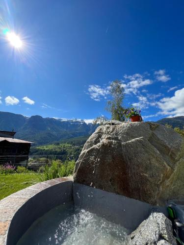a bath tub with a large rock next to a rock at Appartamento Sara in Commezzadura