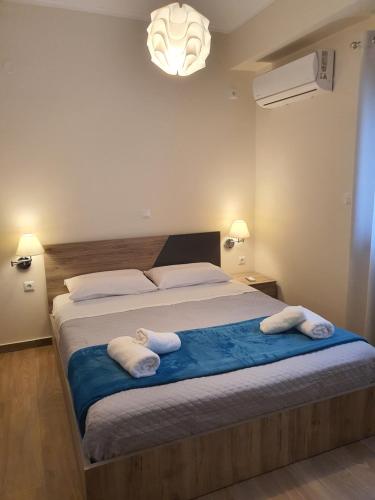 a bedroom with a large bed with two towels on it at Island View Apartments in Moudhros