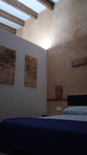 a bedroom with a bed and two paintings on the wall at Apartamento Barrio Alto in Sanlúcar de Barrameda