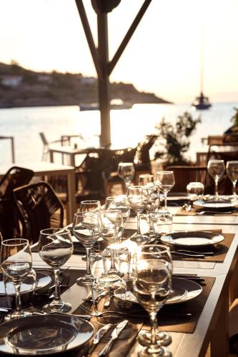 a table with wine glasses and plates on it at Mandraki Beach Resort in Mandraki