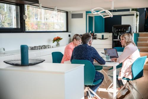 a group of people sitting at a table with a laptop at Péniche de prestige à Namur avec vue sur la Citadelle - A l'Abordage - By Voyages Copine in Namur