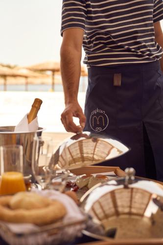 a man is preparing food on a table with a grill at Mandraki Beach Resort in Mandraki