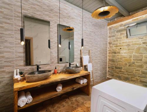 a bathroom with two sinks and a mirror at The Cave Villa in Matala