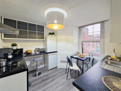 a kitchen and dining room with a table and a counter top at Spacious room with sofa in London