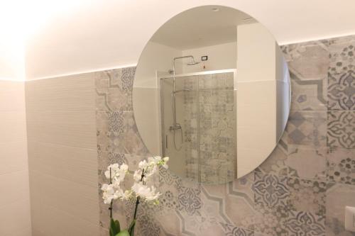 a bathroom with a mirror and flowers in a vase at SUNSEA - Enjoy Your Family in Capo Vaticano