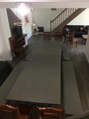una mesa larga en una habitación con sillas y una escalera en Family, en La Réorthe