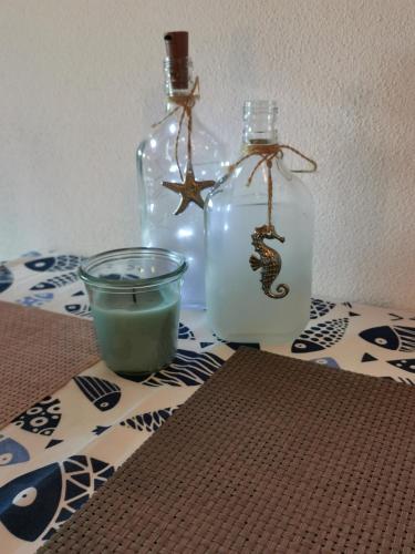 a table with two glass bottles and a candle at Casa Cocco in Sant' Isidoro