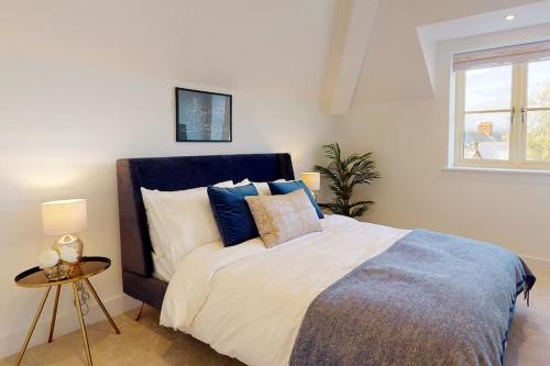 a bedroom with a bed with blue and white pillows at Stylish and Modern One-Bedroom Flat in Dorset in Parkstone