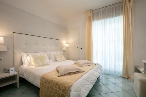 a bedroom with a large bed and a large window at Hotel Ca' Bianca in Riccione