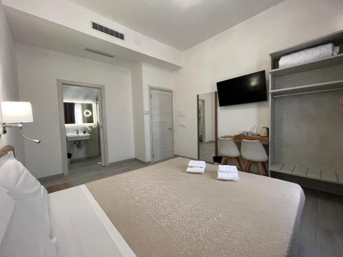 Habitación blanca grande con cama y escritorio. en Hotel Ester en Florencia