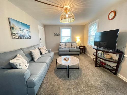 a living room with a couch and a tv at Upper Unit - 4 blocks to the beach, restaurant, and bar district - great deck! in Jacksonville Beach
