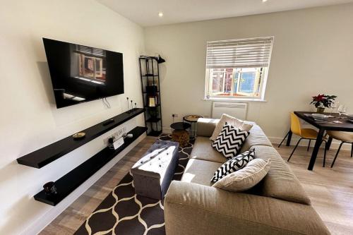 a living room with a couch and a flat screen tv at Stylish and Modern One-Bedroom Flat in Dorset in Parkstone