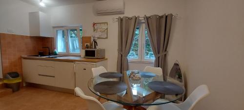 uma pequena cozinha com uma mesa de vidro e cadeiras em Angelo Apartment Center of Split em Split