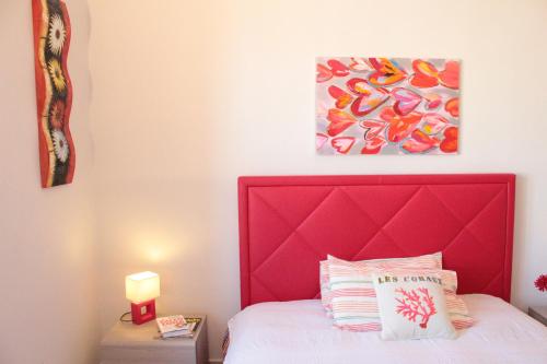 a bedroom with a red headboard and a bed at Casa Tiziano in Cagliari