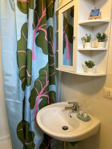 a bathroom with a sink and a shower curtain at La casetta di India in San Domino