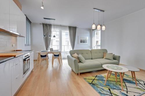 a living room with a couch and a table at Flatbook - Seaside Apartments Tre Mare in Gdańsk